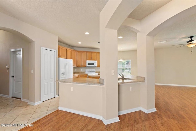 13644 Goodson Pl, Jacksonville, FL 32226 - kitchen featuring arched walkways, light countertops, a ceiling fan, and white appliances