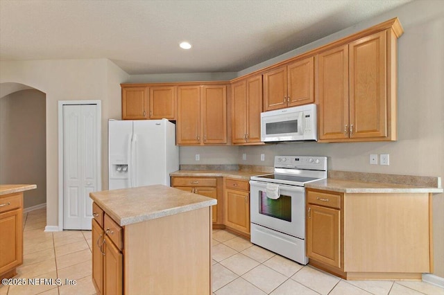 13644 Goodson Pl, Jacksonville, FL 32226 - kitchen featuring a center island, arched walkways, white appliances, light countertops, and light tile patterned floors