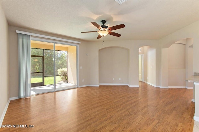 13644 Goodson Pl, Jacksonville, FL 32226 - spare room featuring arched walkways, a ceiling fan, wood finished floors, and baseboards