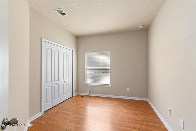13644 Goodson Pl, Jacksonville, FL 32226 - unfurnished bedroom with light wood-type flooring, baseboards, visible vents, and a textured ceiling