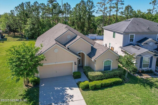 13644 Goodson Pl, Jacksonville, FL 32226 - view of front of property featuring a garage, driveway, a front lawn, and stucco siding