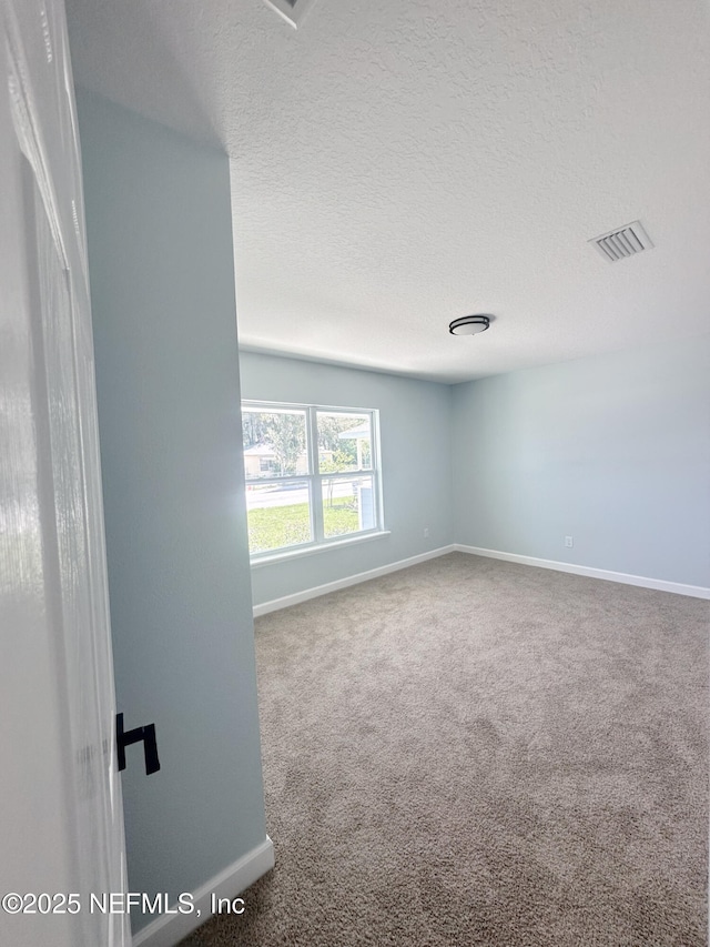 112 Moseley Ave, Palatka, FL 32177 - carpeted empty room with baseboards and a textured ceiling