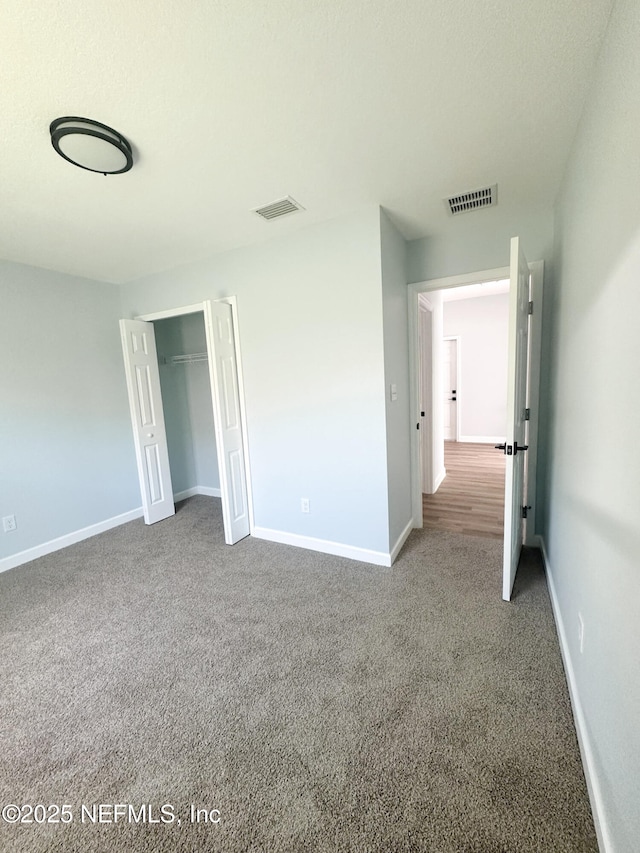 112 Moseley Ave, Palatka, FL 32177 - unfurnished bedroom featuring carpet, a closet, and baseboards