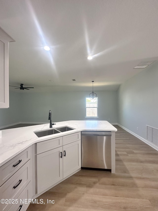 112 Moseley Ave, Palatka, FL 32177 - kitchen featuring stainless steel dishwasher, a sink, light wood finished floors, and light stone counters