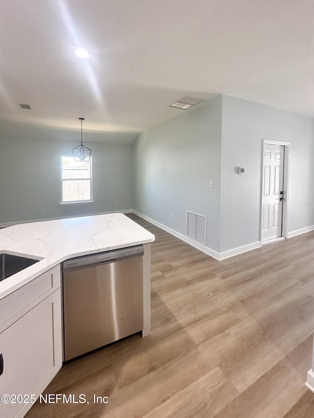 112 Moseley Ave, Palatka, FL 32177 - kitchen featuring stainless steel dishwasher, light stone countertops, hanging light fixtures, light wood-type flooring, and lofted ceiling