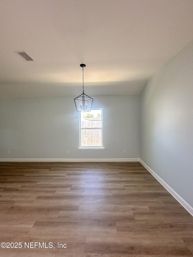 112 Moseley Ave, Palatka, FL 32177 - empty room featuring baseboards, wood finished floors, and a chandelier