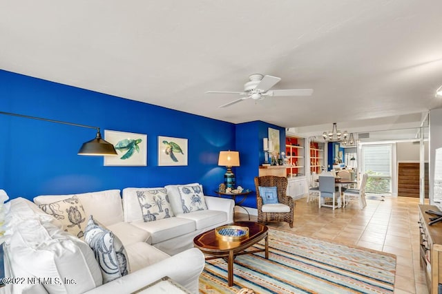 living room featuring tile patterned flooring and ceiling fan with notable chandelier
