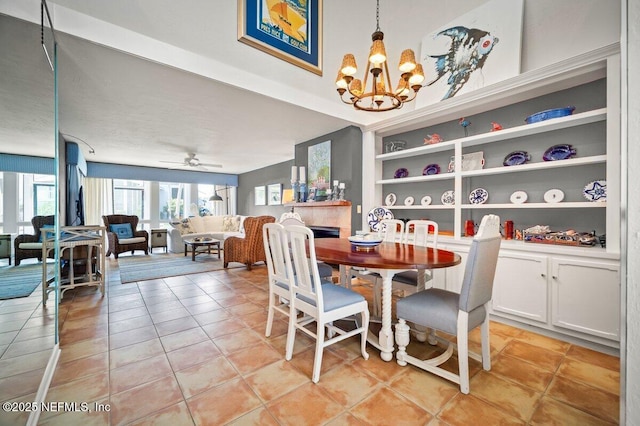 272 Deer Run Ln, Ponte Vedra Beach, FL 32082 - dining space with light tile patterned floors, a chandelier, a tiled fireplace, and ceiling fan