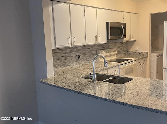 5006 Knightsbridge Cir N, Jacksonville, FL 32244 - kitchen featuring a sink, stainless steel microwave, tasteful backsplash, electric range, and light stone counters