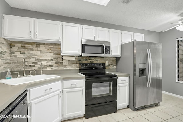 kitchen featuring light countertops, a sink, black appliances, and white cabinetry