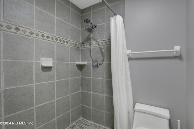full bathroom featuring toilet and tiled shower