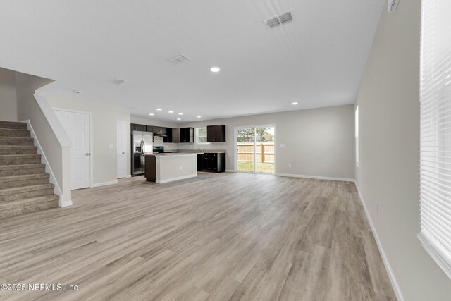 12171 Calais St, Jacksonville, FL 32224 - unfurnished living room featuring light wood-style flooring, baseboards, visible vents, recessed lighting, and stairway
