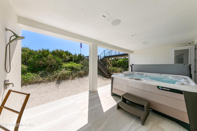 view of patio featuring a hot tub and stairs