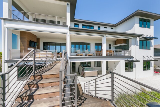back of house featuring stucco siding and a balcony