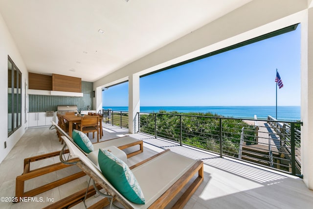 balcony featuring outdoor dining space, a water view, and area for grilling