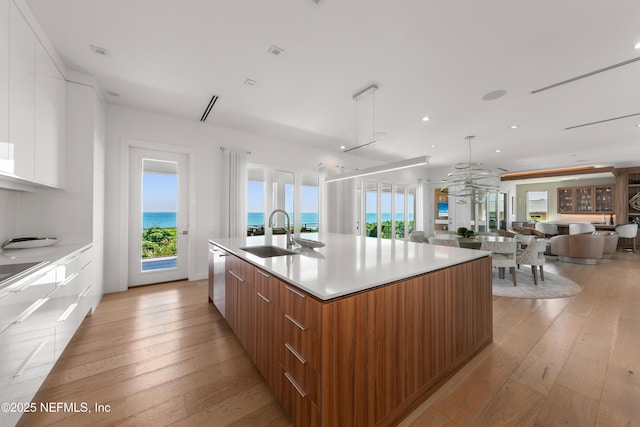 kitchen featuring a sink, modern cabinets, a large island, and light wood-style flooring