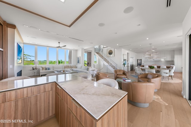 kitchen with ceiling fan, open floor plan, light wood-type flooring, visible vents, and modern cabinets