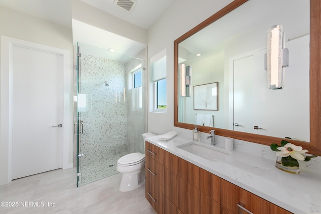full bathroom with vanity, a shower stall, toilet, and visible vents