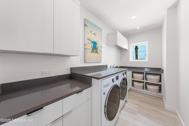 laundry area featuring separate washer and dryer, cabinet space, and baseboards