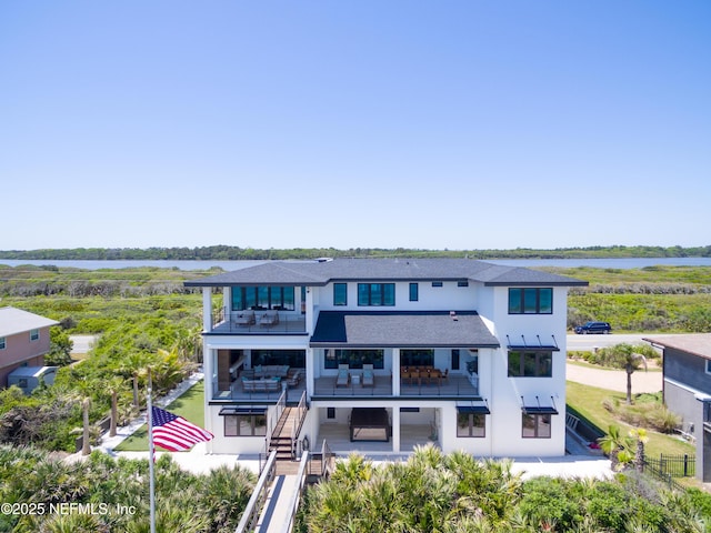 rear view of property with an outdoor living space, a water view, a balcony, and stairway