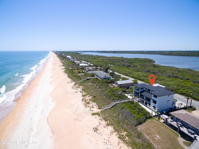 drone / aerial view featuring a water view and a beach view