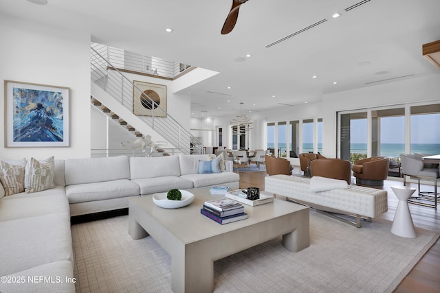 living area featuring stairs, recessed lighting, ceiling fan, and wood finished floors