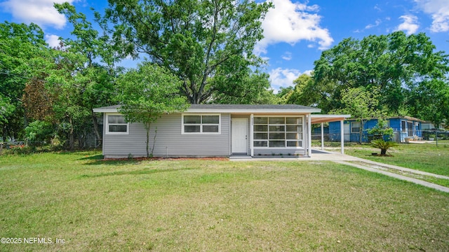 9265 Danville Ave, Jacksonville, FL 32208 - back of house featuring a yard, an attached carport, and driveway