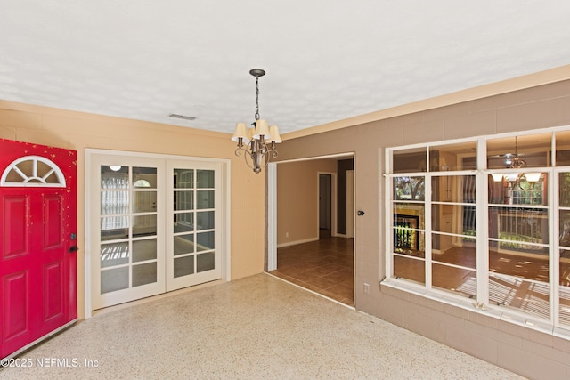 unfurnished dining area featuring speckled floor, visible vents, and an inviting chandelier