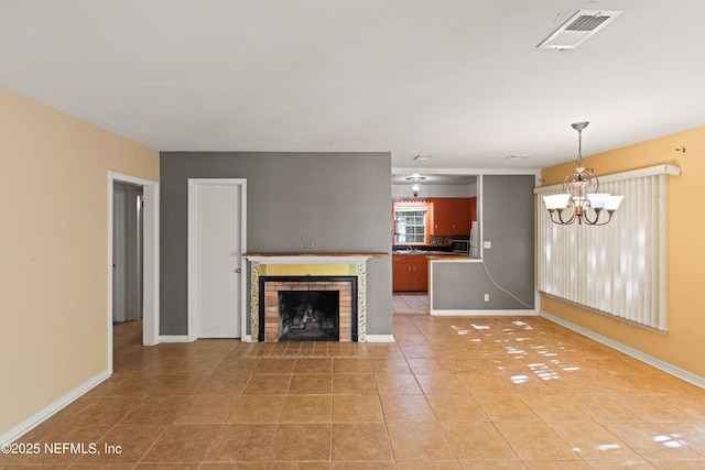 unfurnished living room with a chandelier, light tile patterned floors, baseboards, a brick fireplace, and visible vents