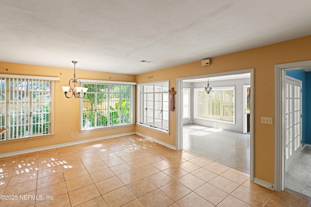 unfurnished dining area with baseboards, visible vents, a notable chandelier, and tile patterned floors