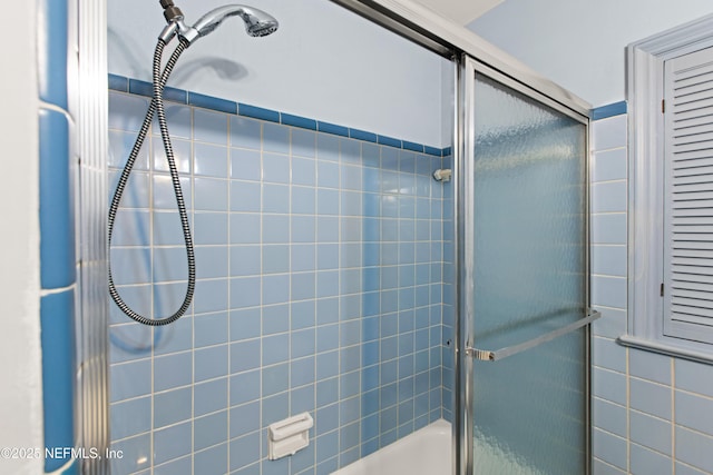 bathroom with bath / shower combo with glass door