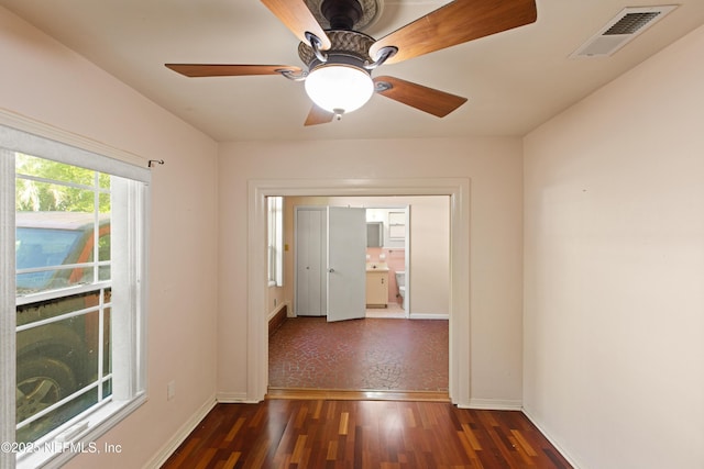 hall with baseboards, wood finished floors, and visible vents