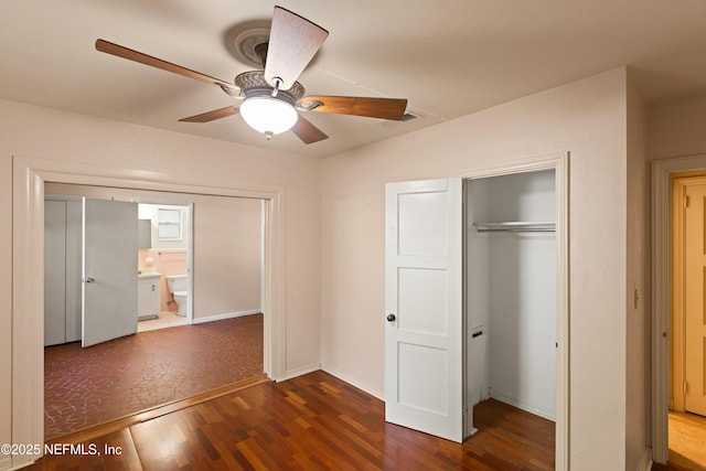 unfurnished bedroom featuring wood finished floors, a closet, ceiling fan, baseboards, and visible vents