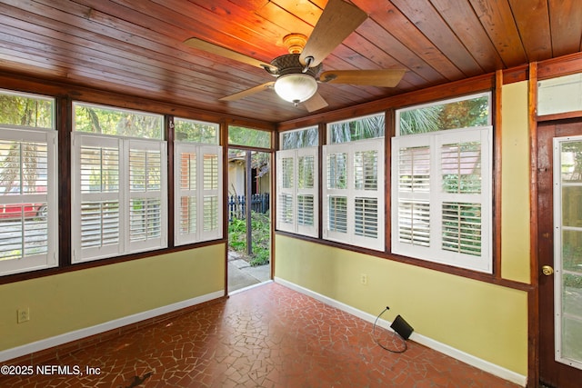 unfurnished sunroom featuring wood ceiling and baseboards