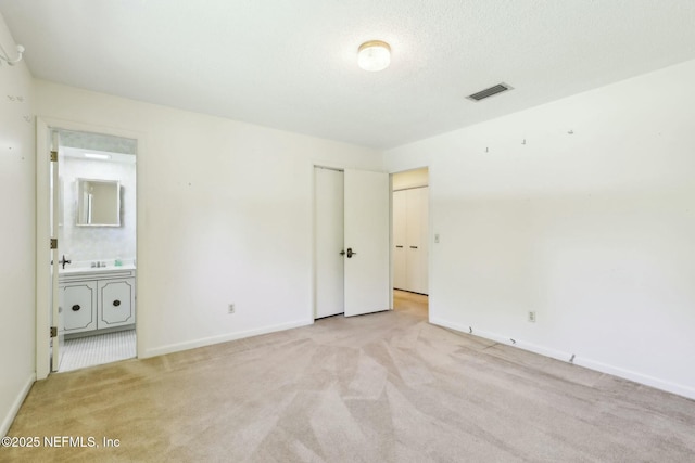 2815 Sylvan Ln S, Jacksonville, FL 32257 - unfurnished bedroom featuring ensuite bath, baseboards, visible vents, and light colored carpet