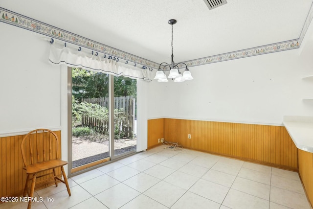 2815 Sylvan Ln S, Jacksonville, FL 32257 - unfurnished dining area with an inviting chandelier, visible vents, wood walls, and wainscoting