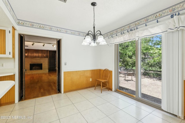 2815 Sylvan Ln S, Jacksonville, FL 32257 - dining area with a wainscoted wall, wooden walls, track lighting, a fireplace, and a notable chandelier