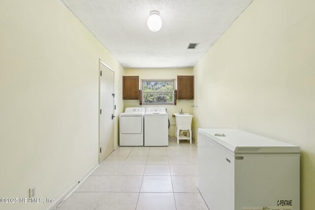 2815 Sylvan Ln S, Jacksonville, FL 32257 - laundry room featuring a textured ceiling, light tile patterned floors, cabinet space, visible vents, and independent washer and dryer