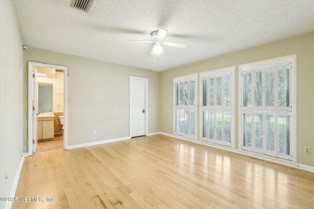 2815 Sylvan Ln S, Jacksonville, FL 32257 - unfurnished bedroom featuring light wood-style floors, a textured ceiling, baseboards, and visible vents