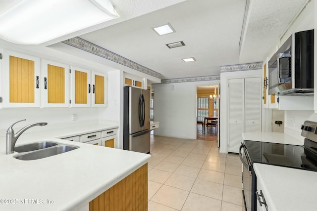 2815 Sylvan Ln S, Jacksonville, FL 32257 - kitchen with an inviting chandelier, light countertops, light tile patterned floors, a sink, and appliances with stainless steel finishes