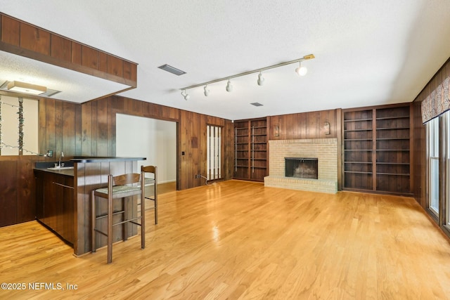 2815 Sylvan Ln S, Jacksonville, FL 32257 - interior space with light wood-type flooring, visible vents, built in features, a brick fireplace, and wooden walls