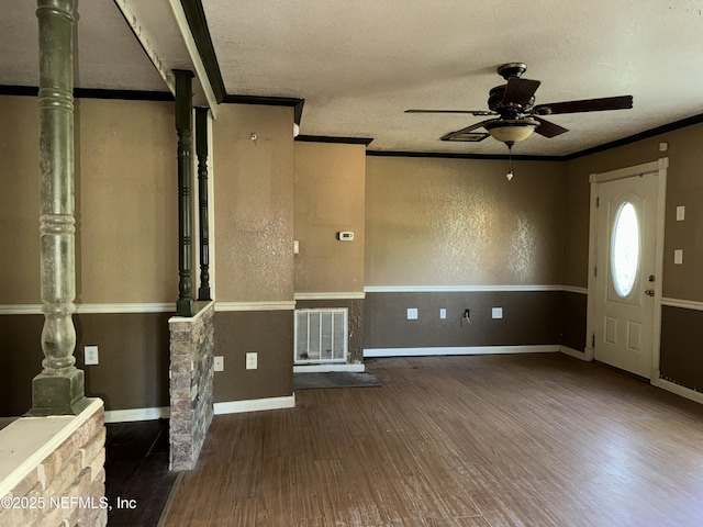 foyer entrance featuring a textured ceiling, wood finished floors, a ceiling fan, and visible vents