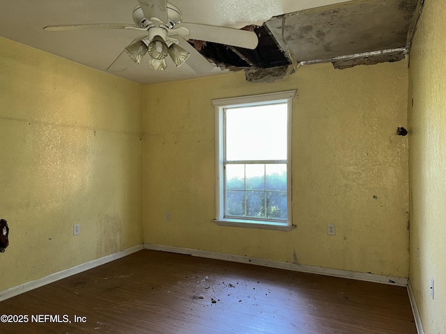 spare room featuring wood finished floors, baseboards, and a ceiling fan