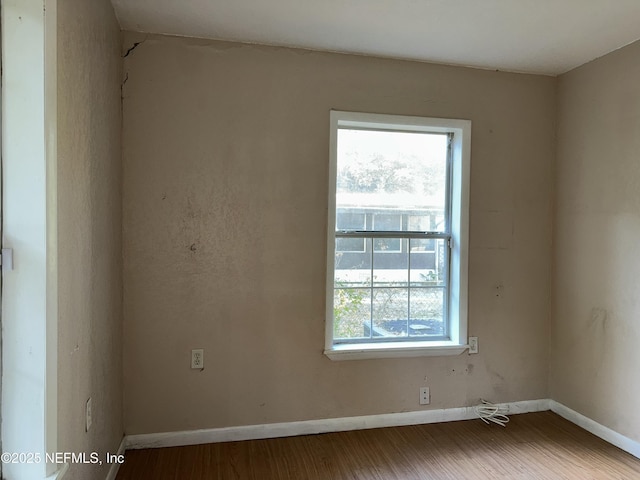 empty room featuring wood finished floors and baseboards