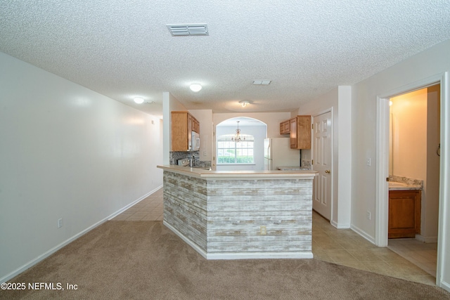 2631 Tuscany Glen Dr, Orange Park, FL 32065 - kitchen featuring arched walkways, a textured ceiling, visible vents, white appliances, and light tile patterned floors