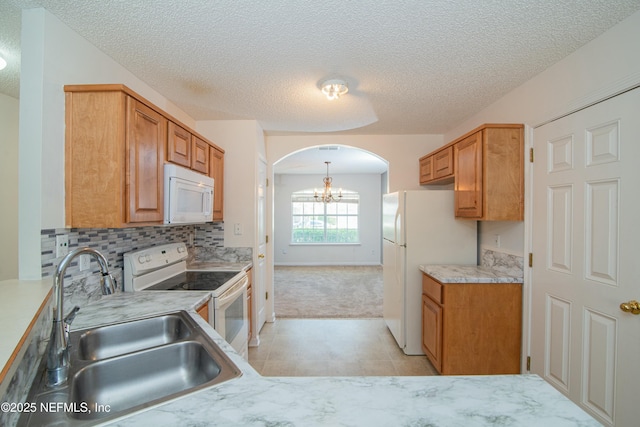 2631 Tuscany Glen Dr, Orange Park, FL 32065 - kitchen featuring arched walkways, a sink, a chandelier, white appliances, and light countertops