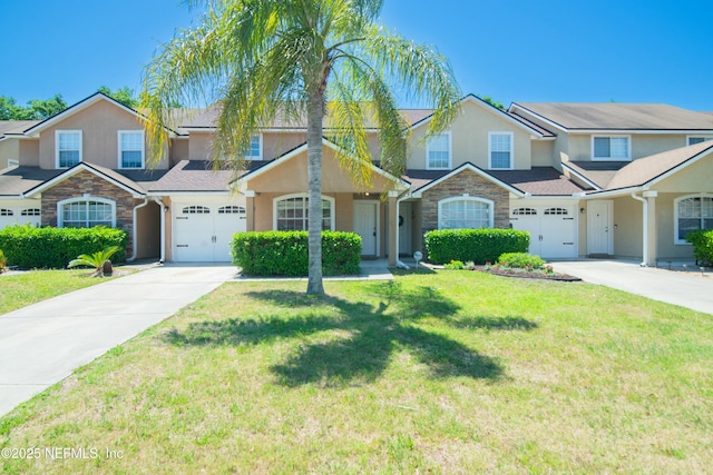 2631 Tuscany Glen Dr, Orange Park, FL 32065 - townhome / multi-family property featuring stone siding, a front lawn, driveway, and stucco siding