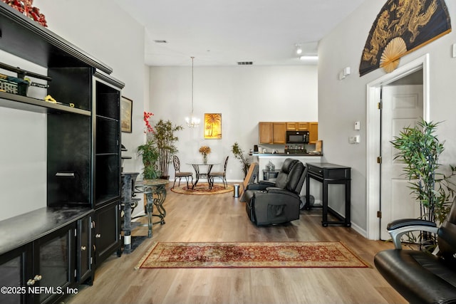 3671 Kirkpatrick Cir Unit 14, Jacksonville, FL 32210 - sitting room with baseboards, light wood finished floors, visible vents, a chandelier, and a high ceiling