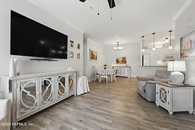 115 Legendary Dr Unit 106, Saint Augustine, FL 32902 - living area with light wood-style floors, ornamental molding, and ceiling fan with notable chandelier