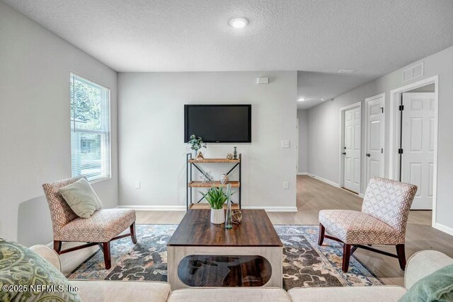 5454 Amazon Ave, Jacksonville, FL 32254 - living area with baseboards, wood finished floors, a textured ceiling, and visible vents